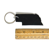 Black leather Nebraska keychain next to ruler, measures 3 inches