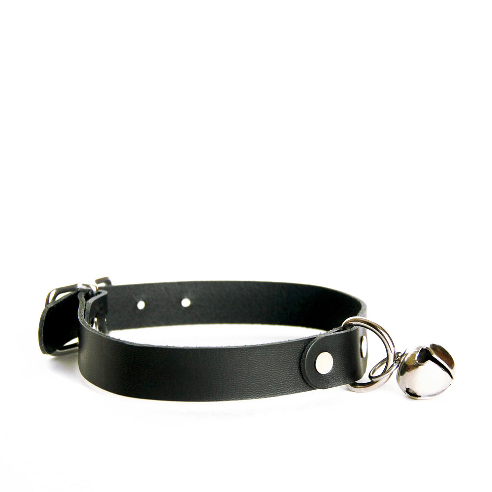 Side view of black leather choker with silver hardware and silver jingle bell. Shows how the bell hangs from D-ring.