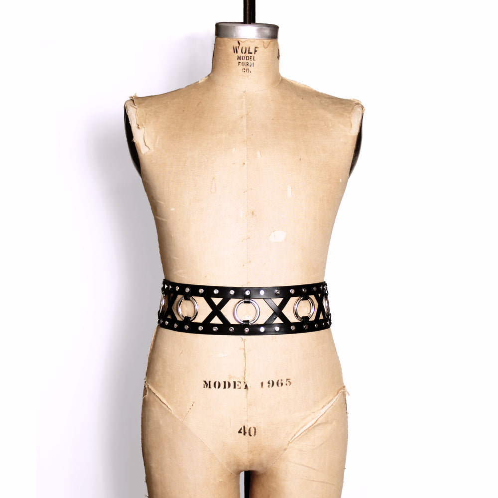 Double strap belt with leather X's and metal O's between the two belts. Belt shown on a dress form.