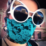 Model wearing a lace mask downtown paired with oversized pointed sunglasses. 