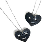 Leather heart necklaces with face. One with circle eyes, one with x eyes