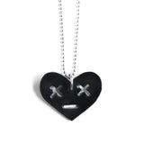 Leather heart necklace with x eyes, close up