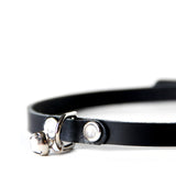 Close up of the mini kitty choker. Shows how d-ring is attached to collar with a small leather strap and jingle bell is attached to d-ring with a small o-ring.
