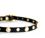 Closeup of black choker shows the alternating sizes of pearl studs: large, small, large, small.....