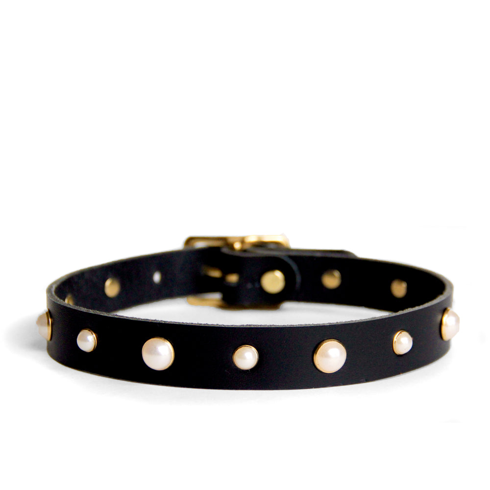Black leather choker with pearl studs trimmed in brass. Shown on a white background.