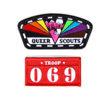 A pink triangle sits at the center of this rainbow patch with “QUEER SCOUTS” text. Red “TROOP 069” patch sits below.