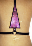 Black leather harness with upside down purple mermaid leather triangle in the center, close up
